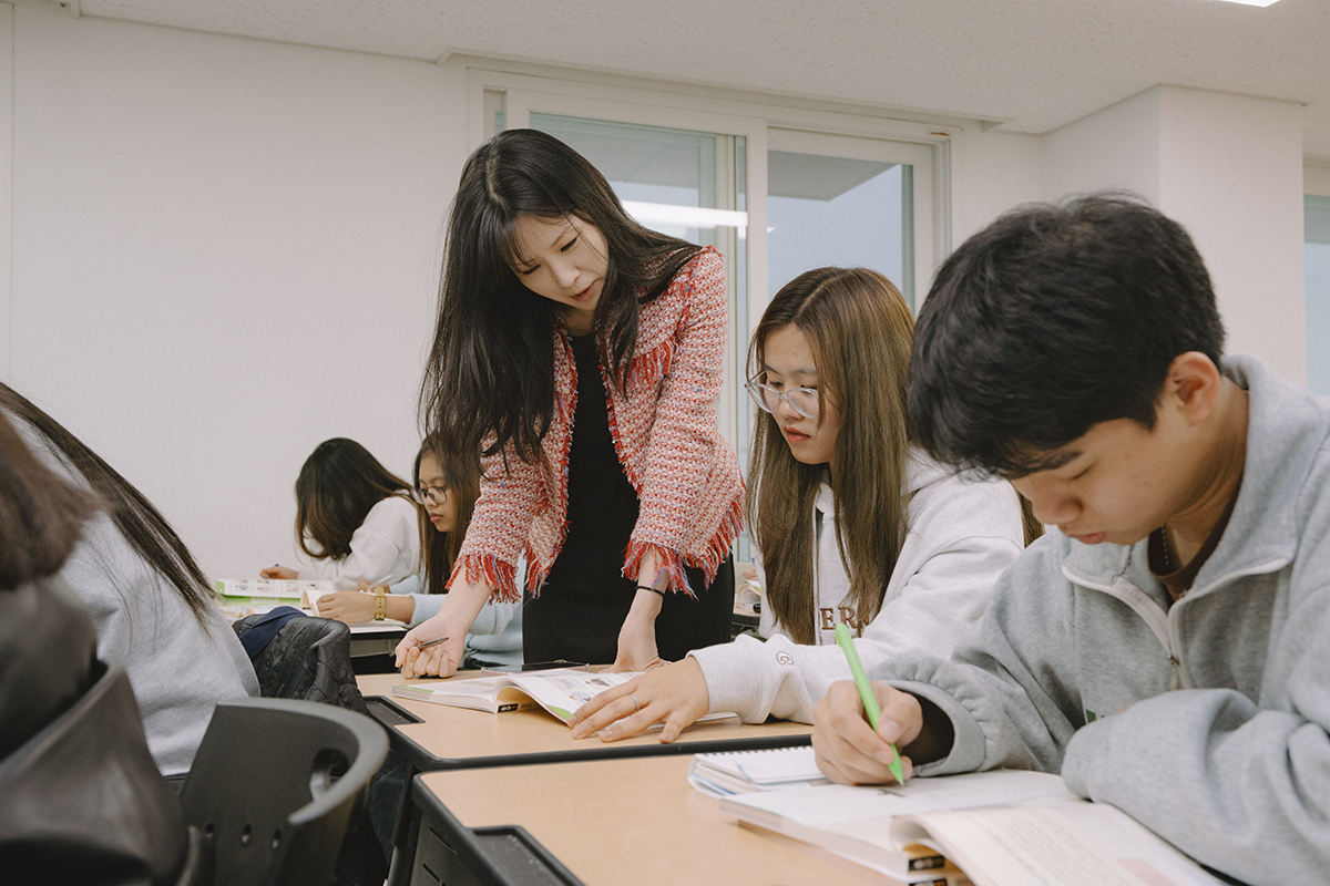 수업중 학생 한명을 지도하는 교수님과 수업듣는 학생들